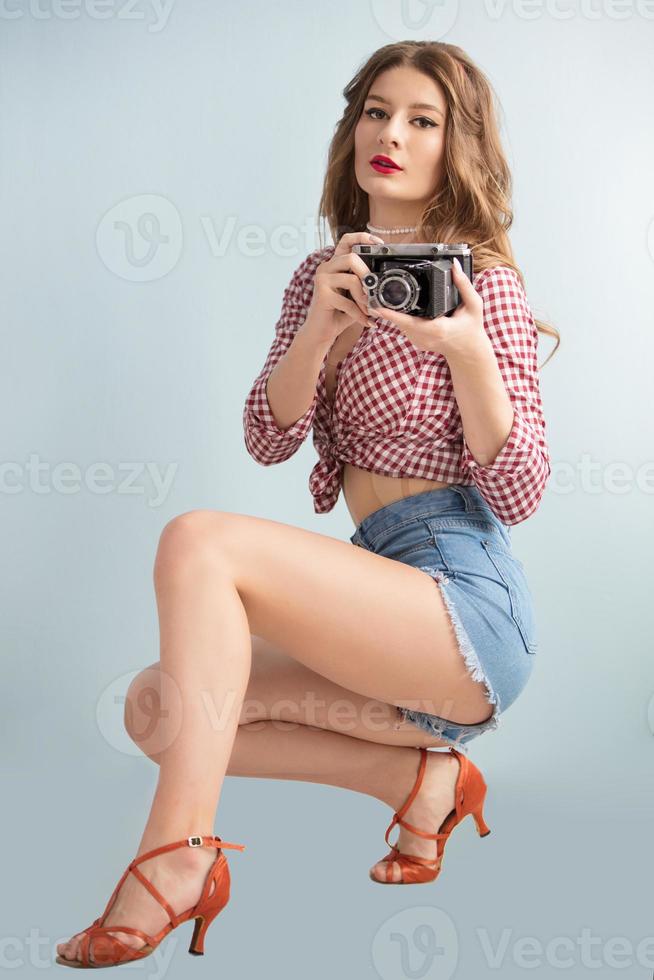 lindo retro menina fotógrafo com uma vintage foto Câmera.