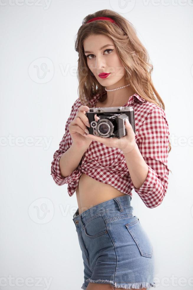 lindo menina com retro Câmera. mulher fotógrafo dentro a estilo do a anos cinquenta foto