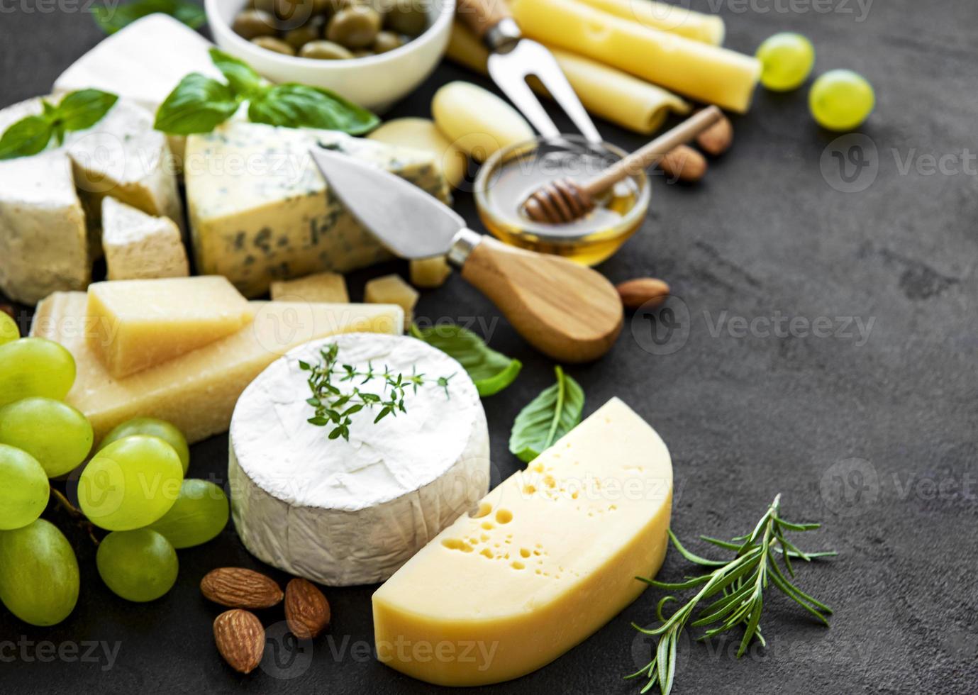 vários tipos de queijos, uvas, mel e salgadinhos foto