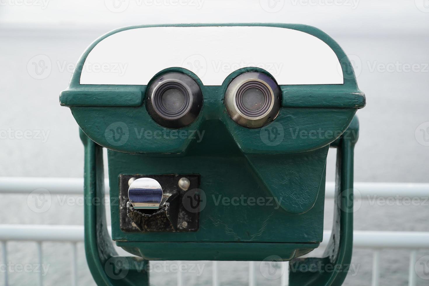verde turista binocular em moedas e desfocado mar em segundo plano foto