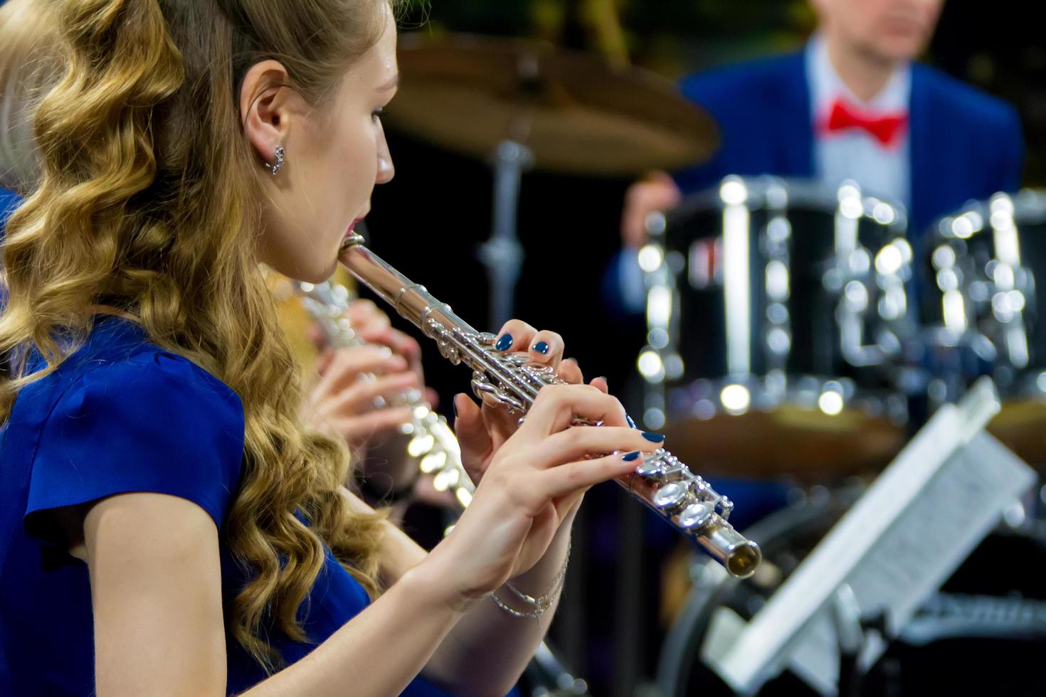 a menina a partir de a orquestra tocam a flauta. foto