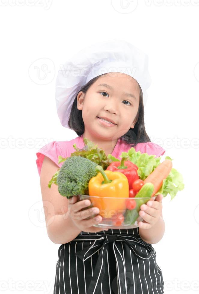 pequeno sorridente chefe de cozinha segurando misturar legumes isolado foto