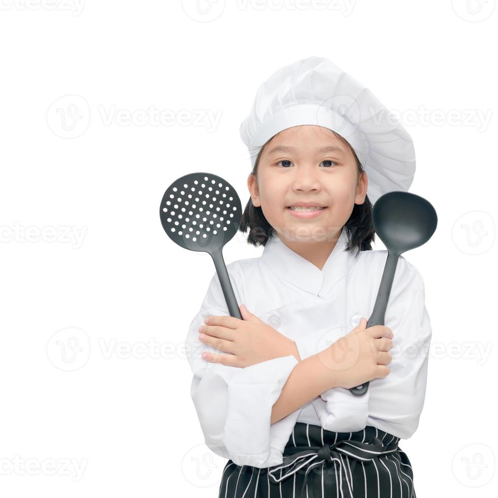 feliz ásia menina chefe de cozinha segurando cozinhando utensílios foto