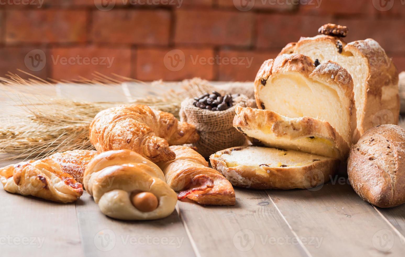 sortimento do cozido pão e trigo em madeira mesa foto