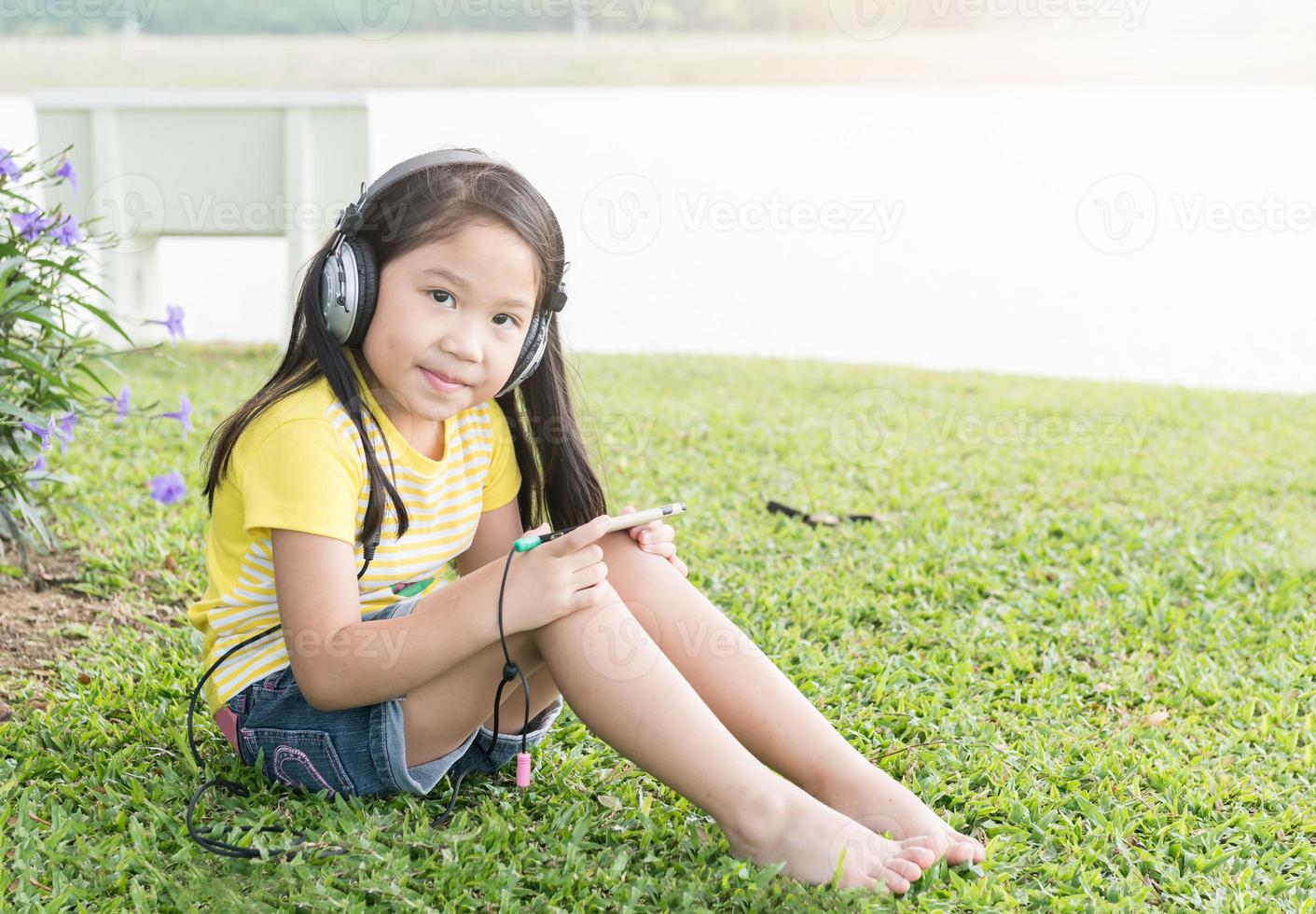 fofa menina ouço música a partir de Móvel telefone foto