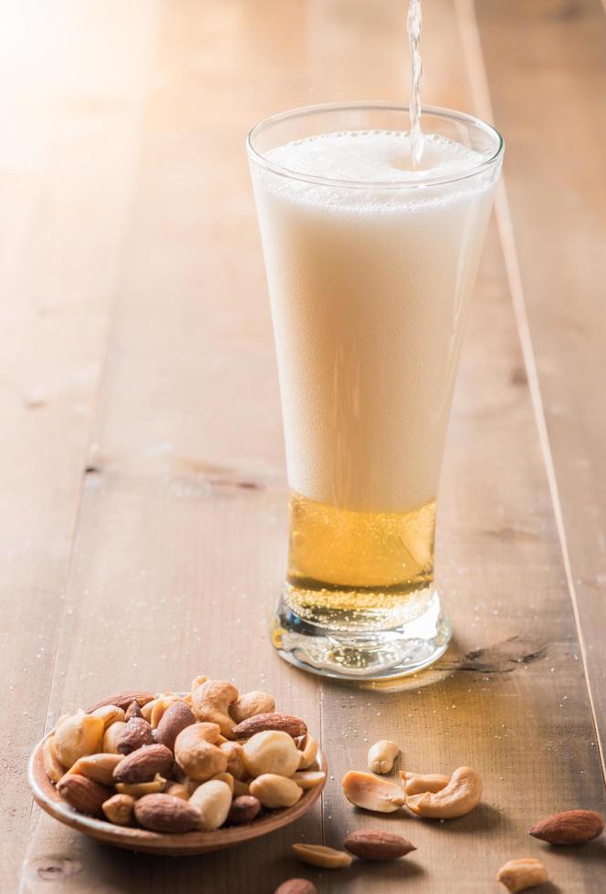 frio Cerveja com coquetel noz em madeira foto