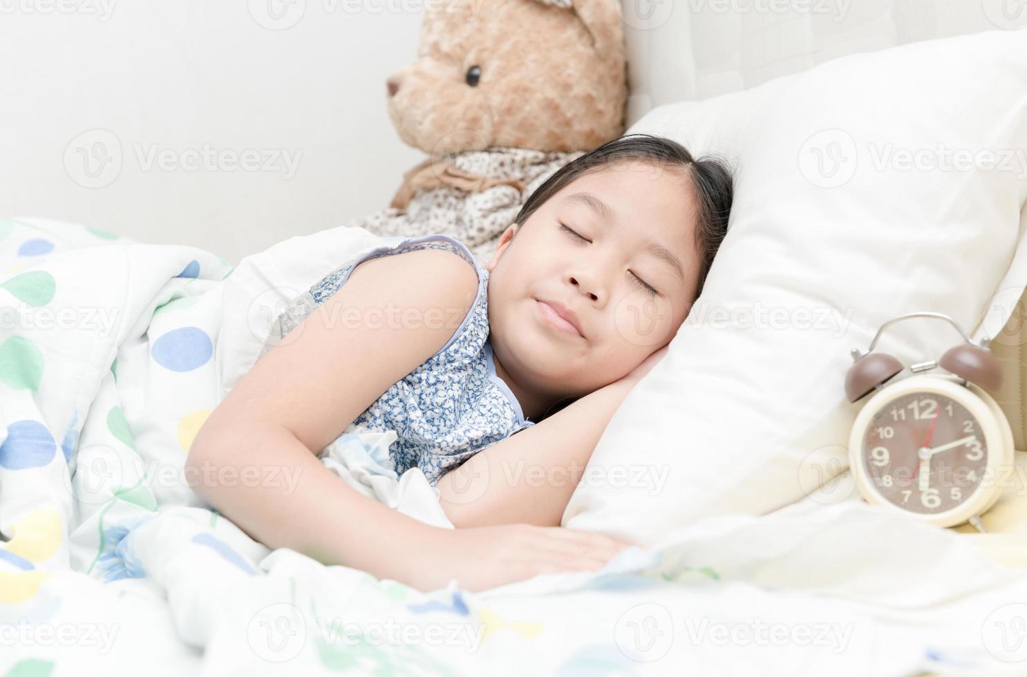 adorável pequeno menina dormindo dentro a cama. foto