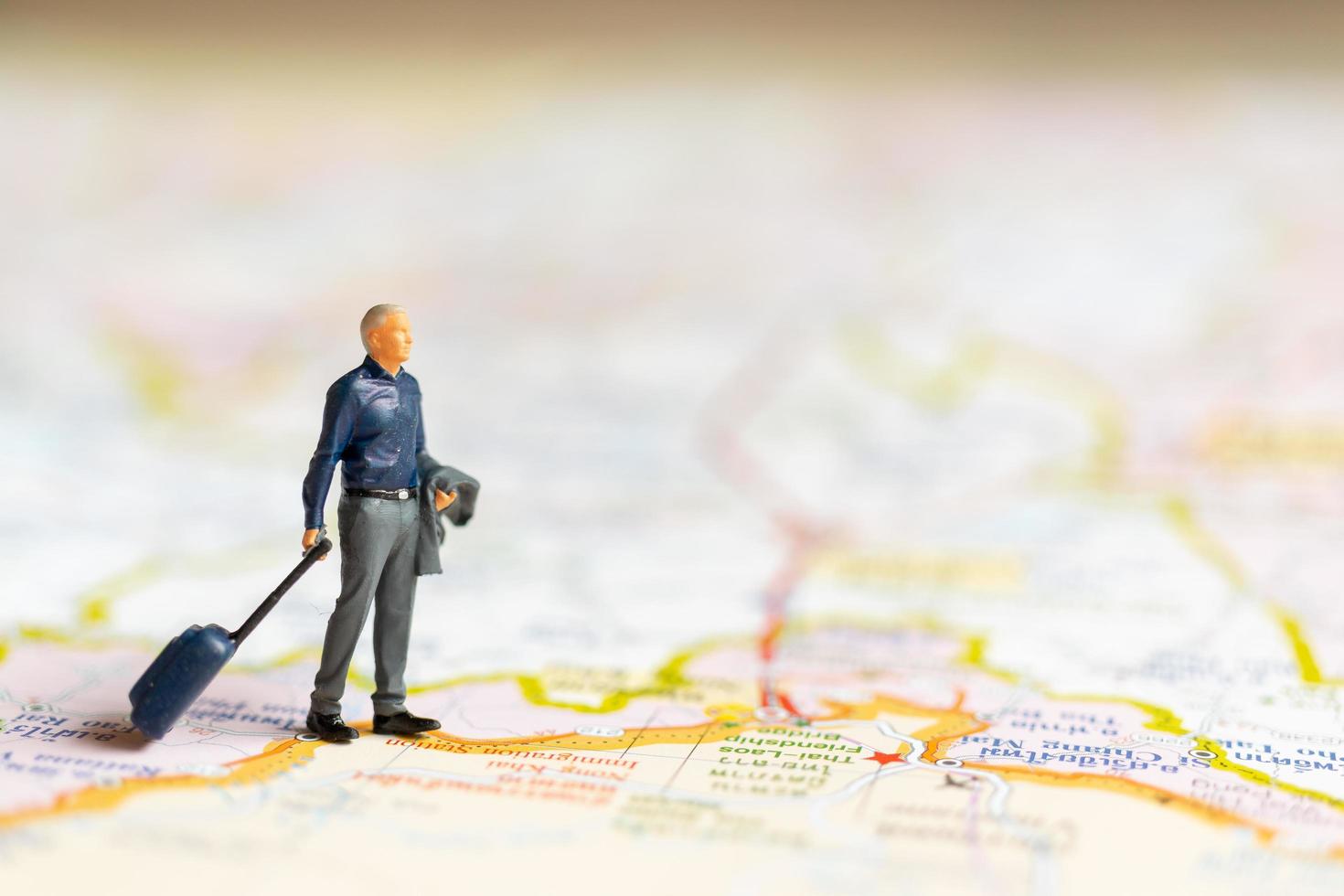 empresário em miniatura no mapa, conceito de viagens foto