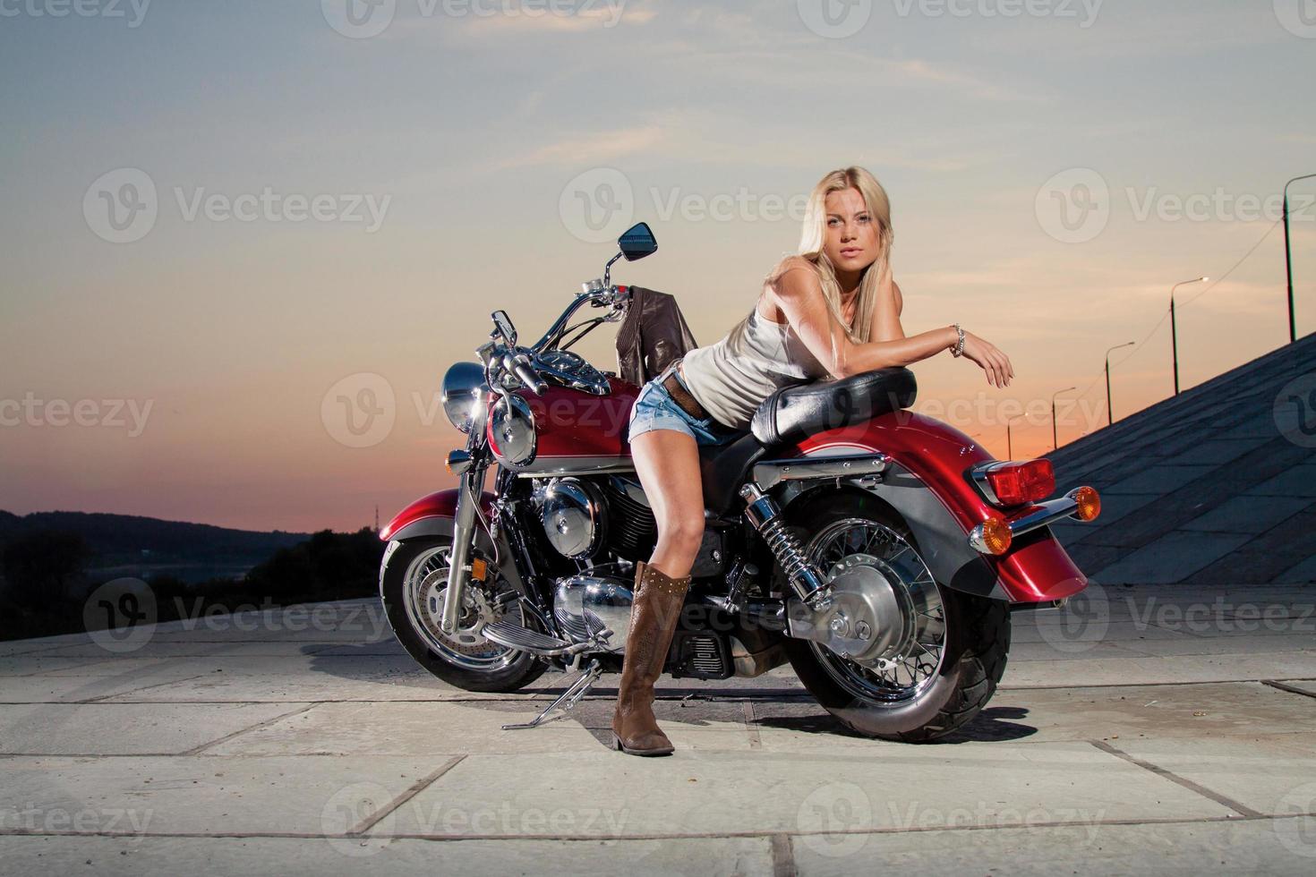 loira sexy sentada em sua motocicleta foto
