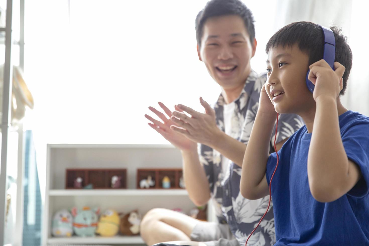 família feliz usando fones de ouvido para ouvir música e sorrindo, aproveite para passar o tempo juntos em casa foto