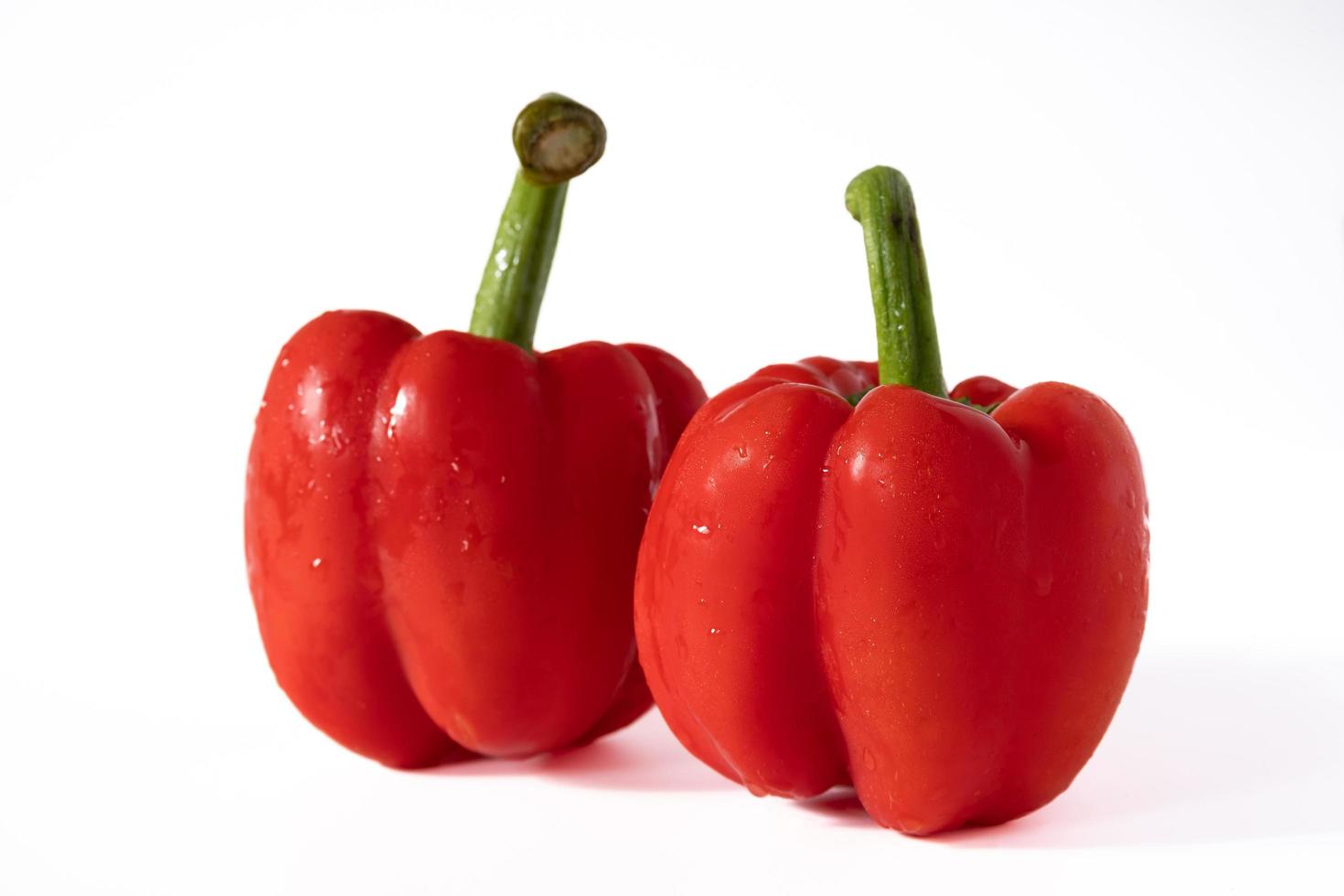 vermelho doce Sino Pimenta com água gotas isolado em branco fundo. foto