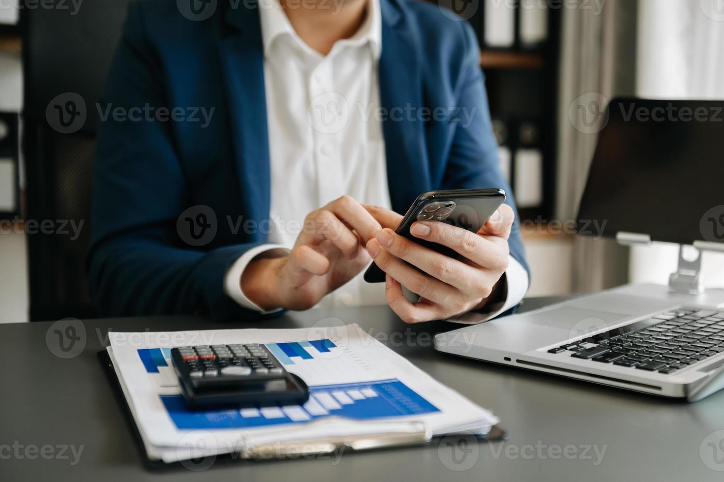 mãos de empresária digitando no smartphone e teclado de laptop no computador de luz matinal, digitando, online no escritório foto