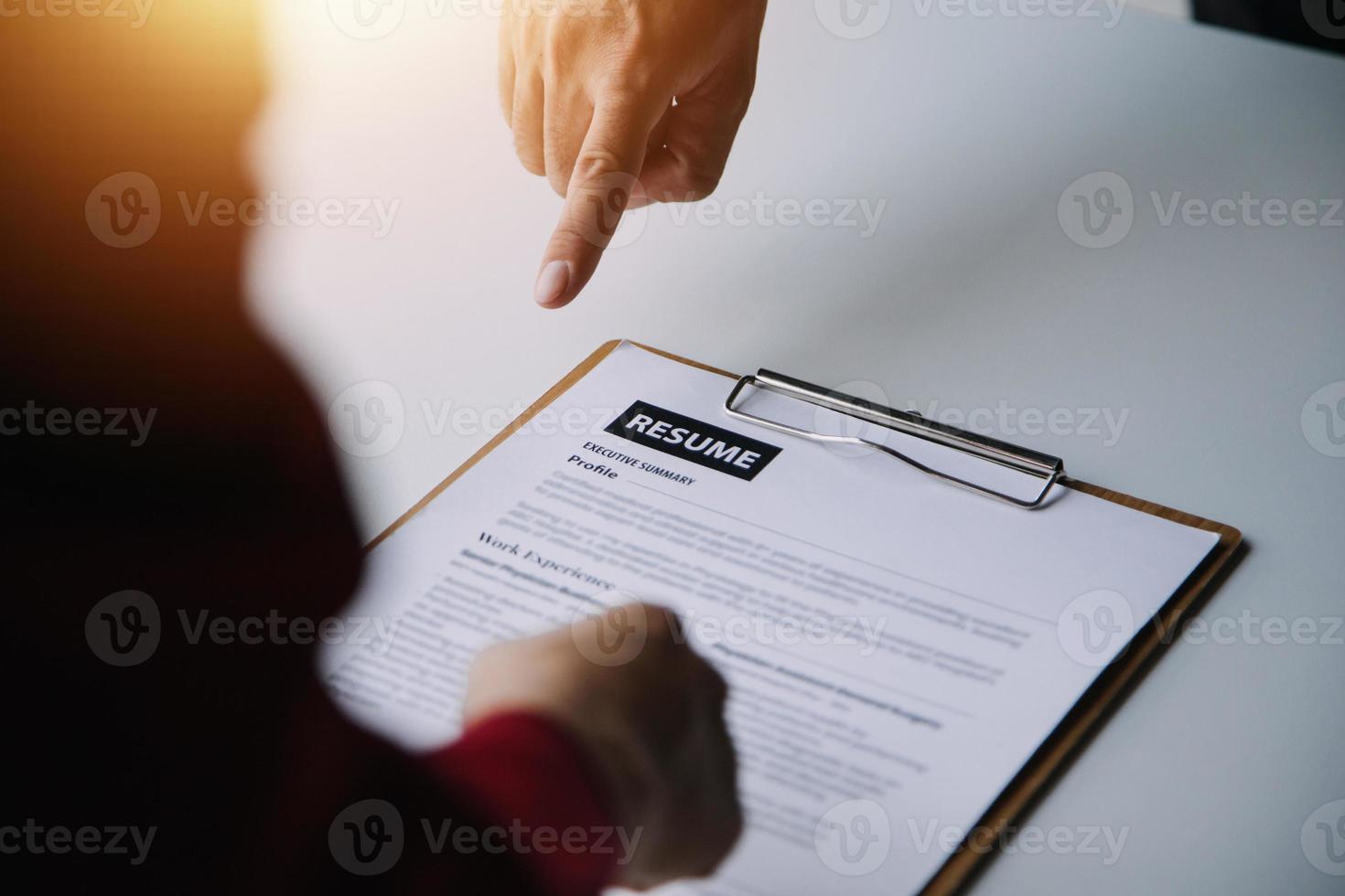 homem de negocios ou trabalho buscador Reveja dele currículo em dele escrivaninha antes mandar para achando uma Novo trabalho com caneta, gravata, óculos e digital tábua. foto