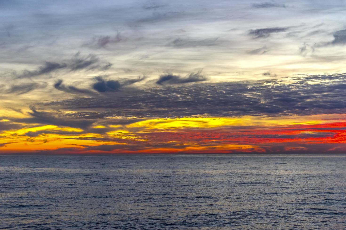 pôr do sol vermelho colorido sobre um corpo de água foto