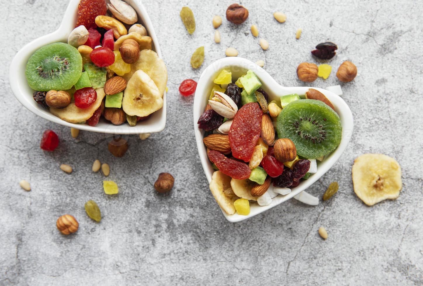 duas tigelas em forma de coração com frutas secas e nozes foto