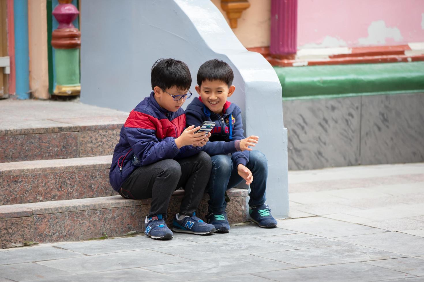 ásia crianças ao ar livre com uma Smartphone. foto