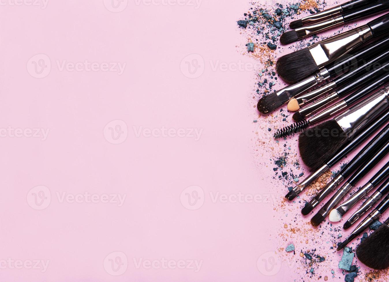 pincéis de maquiagem com espaço de cópia em um fundo rosa foto