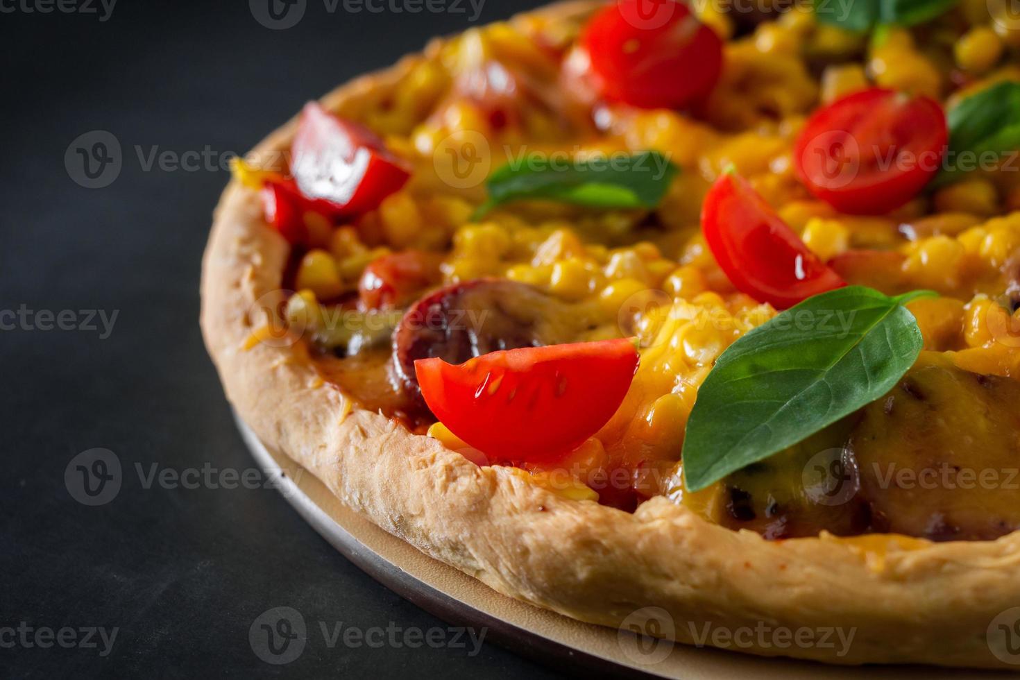 pizza com tomate e close-up de manjericão foto
