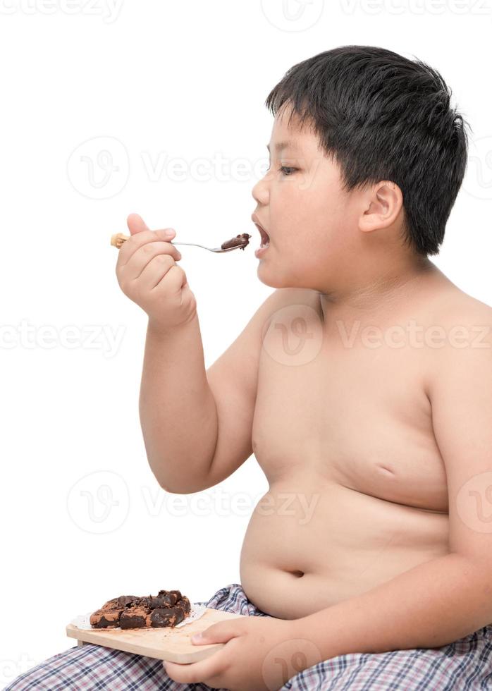 obeso Garoto comer chocolate isolado em branco foto