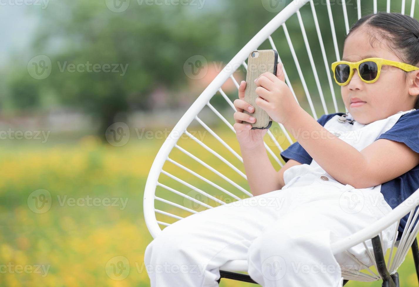 fofa menina segurando Móvel telefone para levar cenário foto