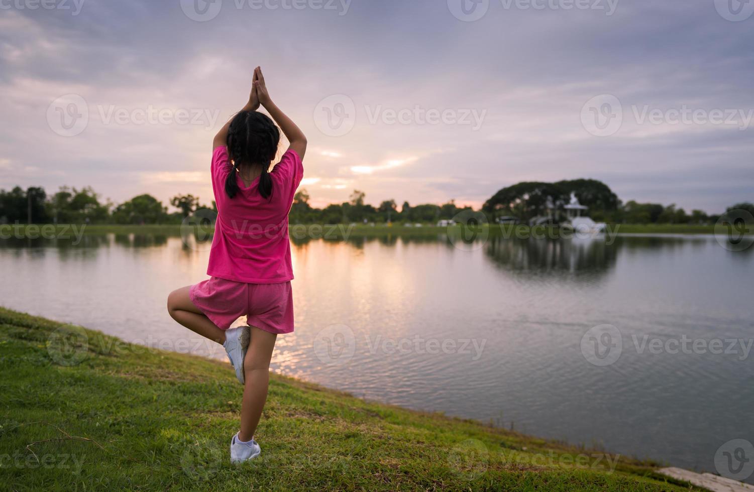 costas lado do pequeno menina jogar ioga ou exercício foto