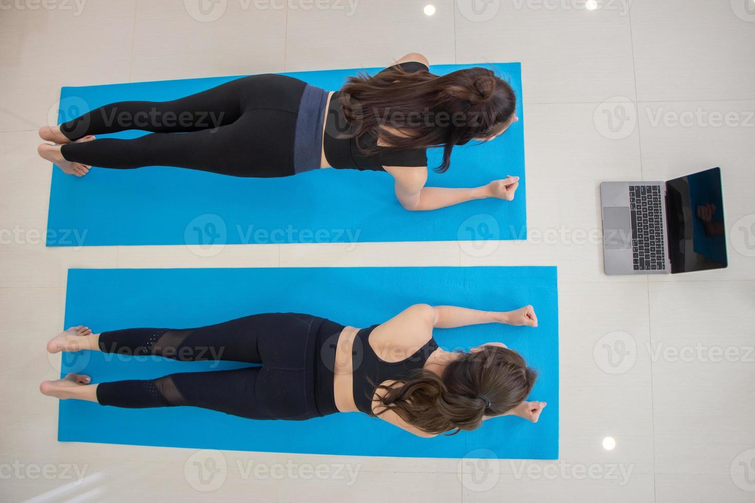 ásia fêmea amigos exercício às lar. ginástica menina dentro Atlético exercício roupas fazendo uma prancha dar certo. foto