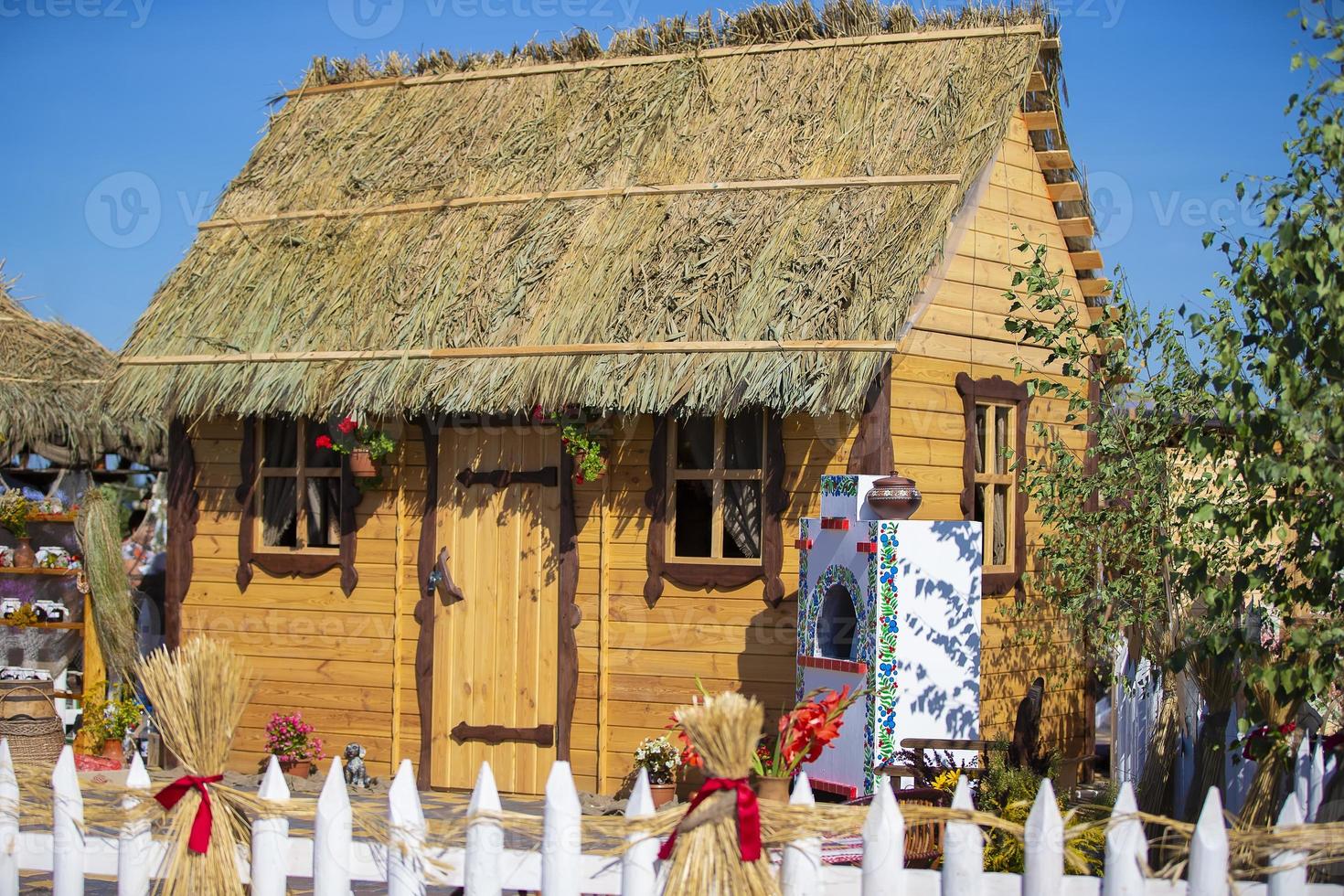 lindo de madeira casa com uma colmo teto. ucraniano cabana. foto