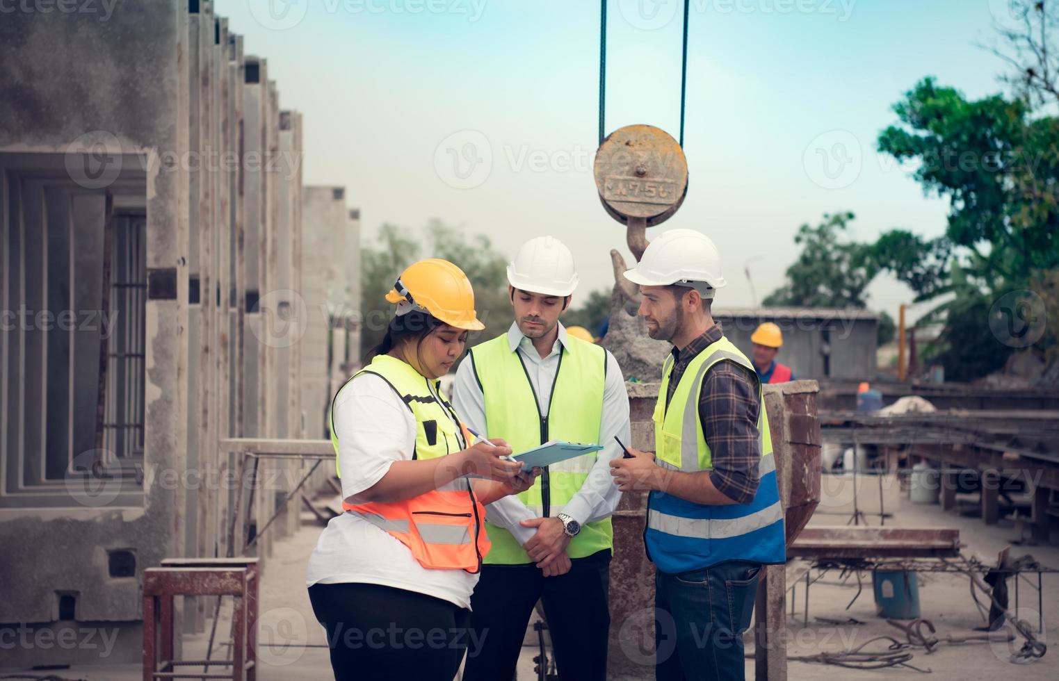 grupo do arquitetos, construção capatazes, e construção engenheiros Reveja a trabalhos e conversa sobre quão a projeto, dentro a construção local. foto