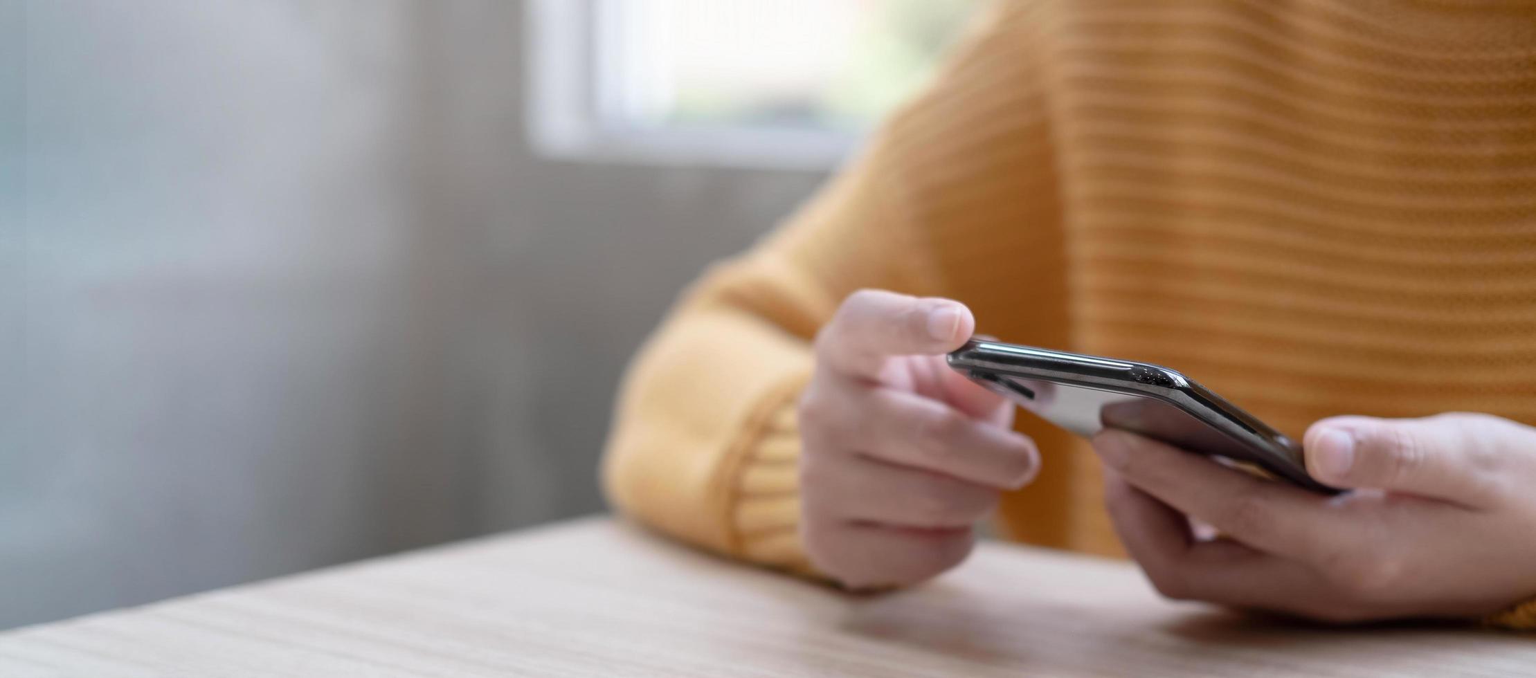 pessoa com um suéter amarelo segurando um telefone com espaço de cópia foto