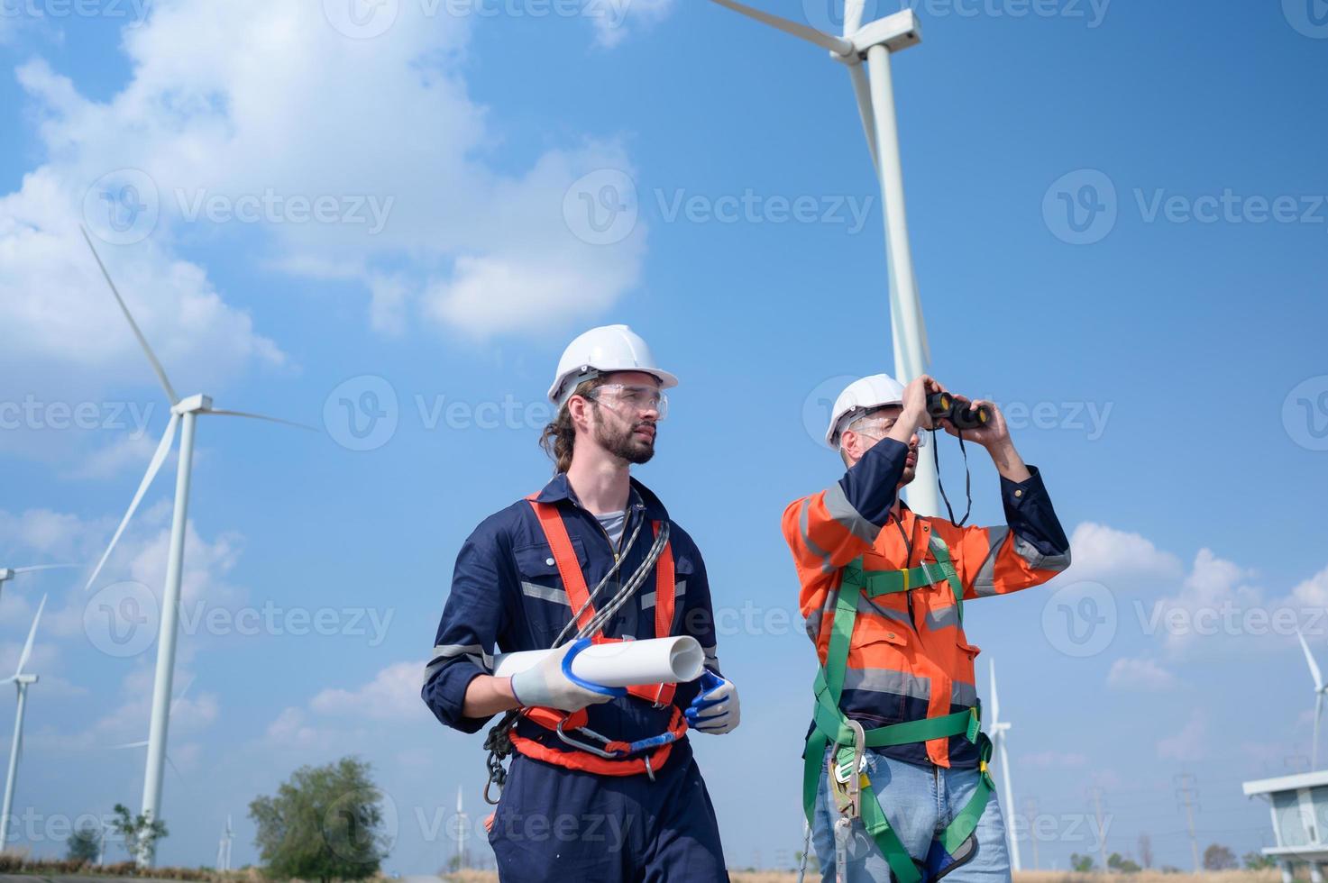 agrimensor e engenheiro examinar a eficiência do gigantesco vento turbinas este transformar vento energia para dentro elétrico energia este é então usava dentro diariamente vida. foto