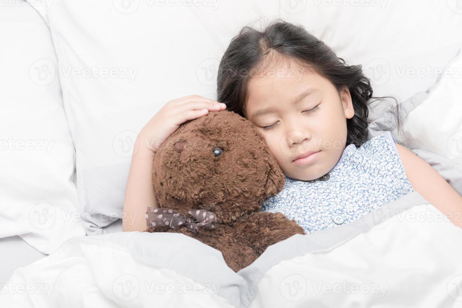 fofa pequeno ásia menina dormir e abraço Urso de pelúcia Urso foto