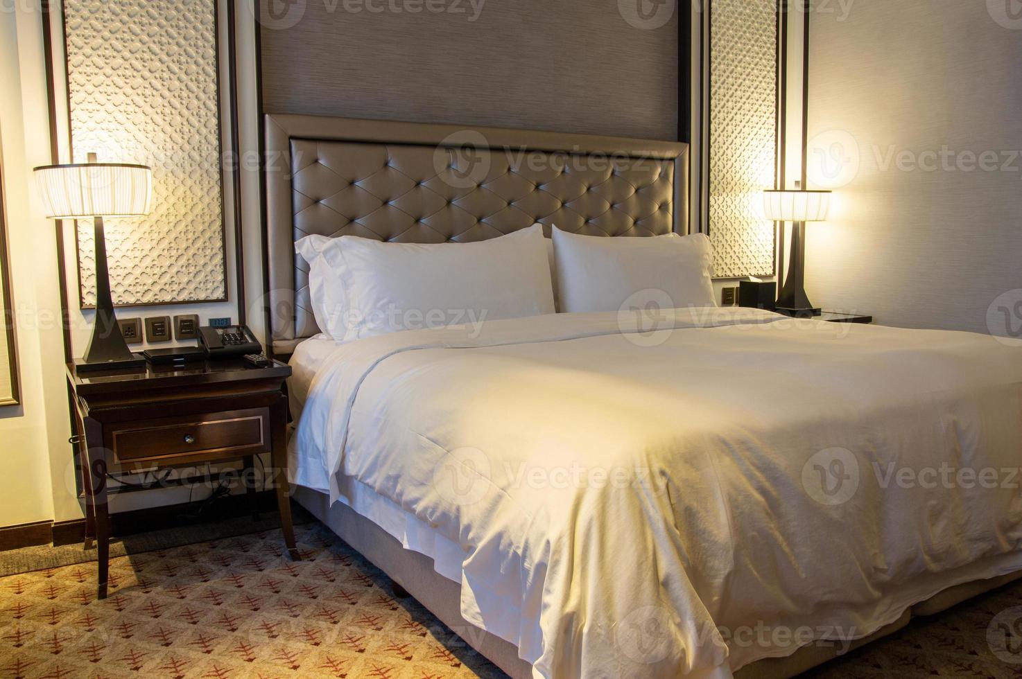 luxo moderno quarto interior com travesseiro e mesa luminária foto