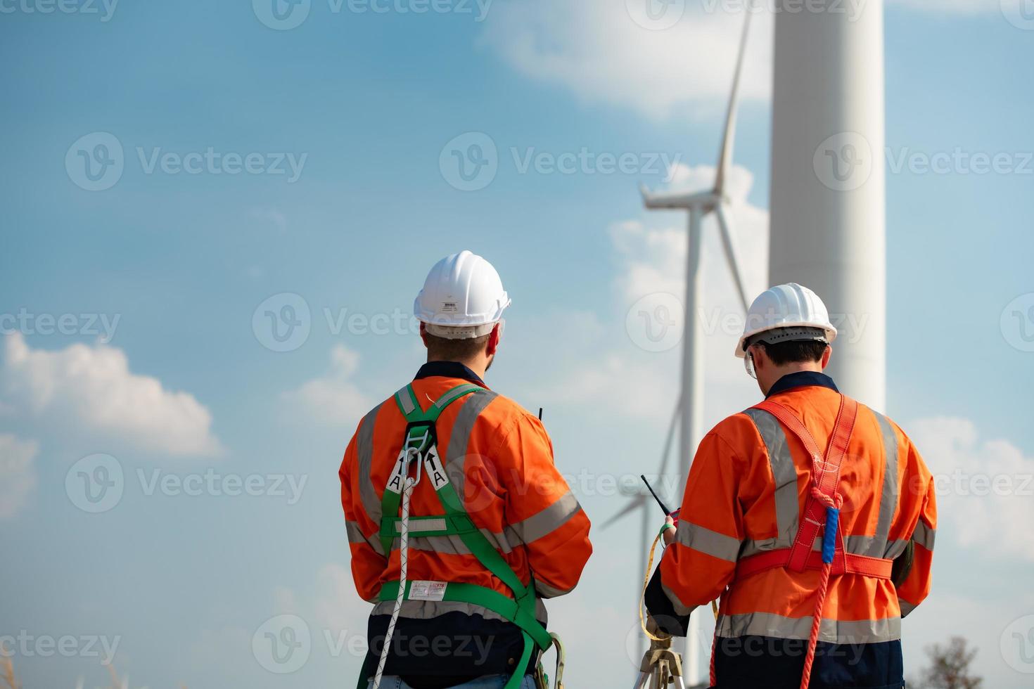 agrimensor e engenheiro examinar a eficiência do gigantesco vento turbinas este transformar vento energia para dentro elétrico energia este é então usava dentro diariamente vida. foto