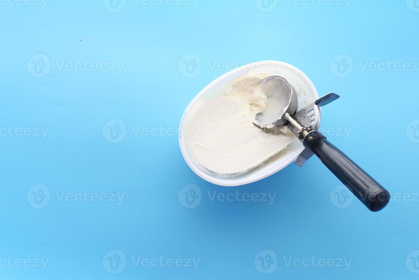sorvete e colher em um fundo azul foto