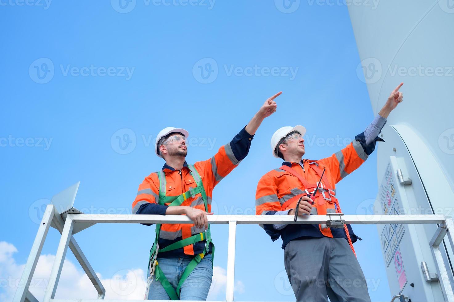 agrimensor e engenheiro examinar a eficiência do gigantesco vento turbinas este transformar vento energia para dentro elétrico energia este é então usava dentro diariamente vida. foto