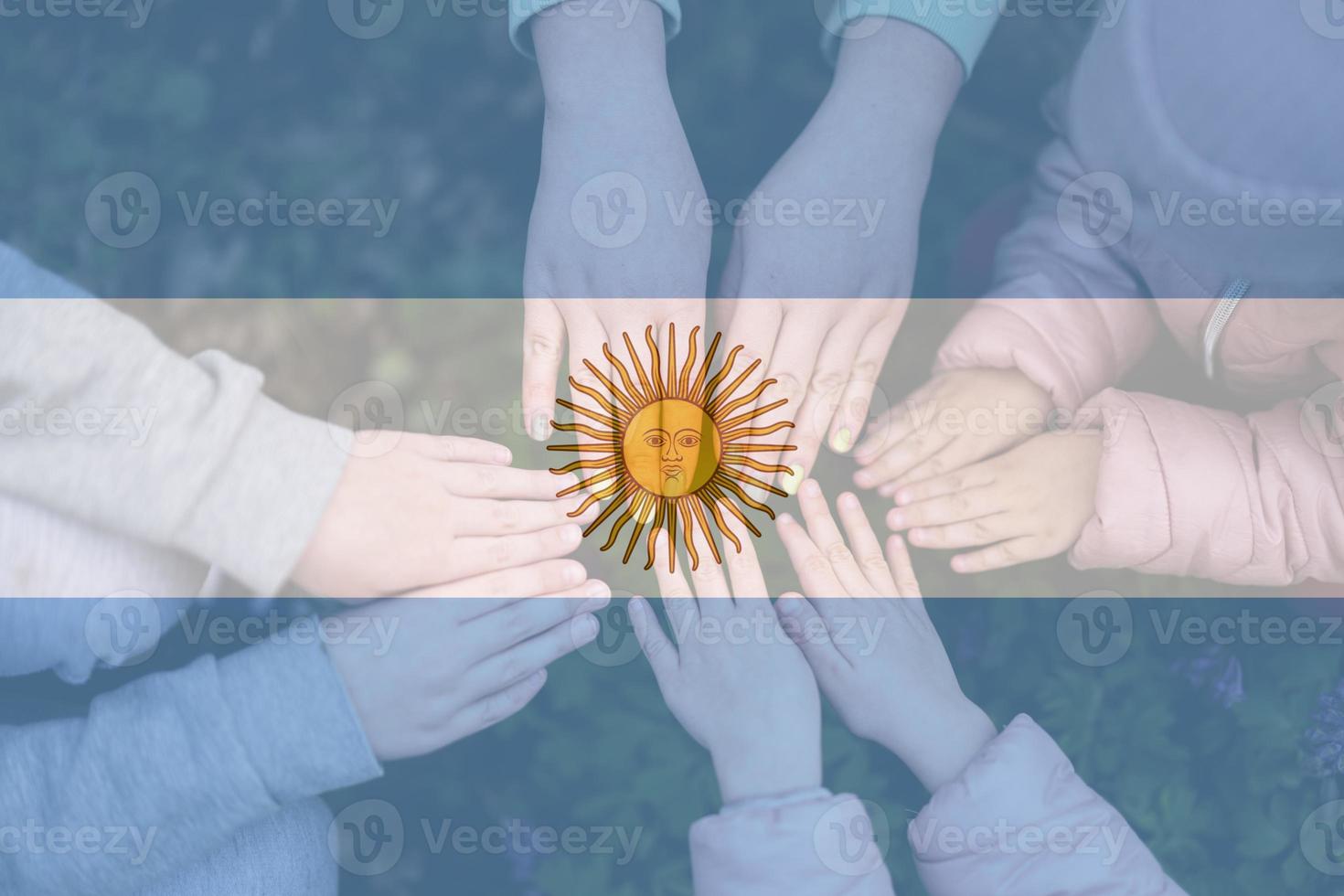 mãos do crianças em fundo do Argentina bandeira. argentina patriotismo e unidade conceito. foto