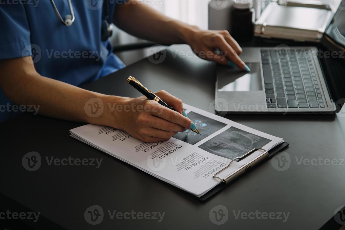 fêmea médico vestindo esfrega dentro hospital corredor usando digital tábua foto