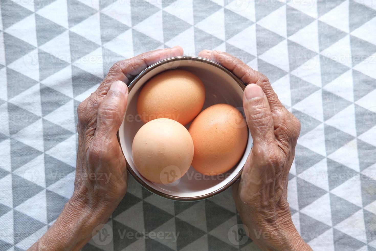 mãos segurando uma tigela de ovos foto