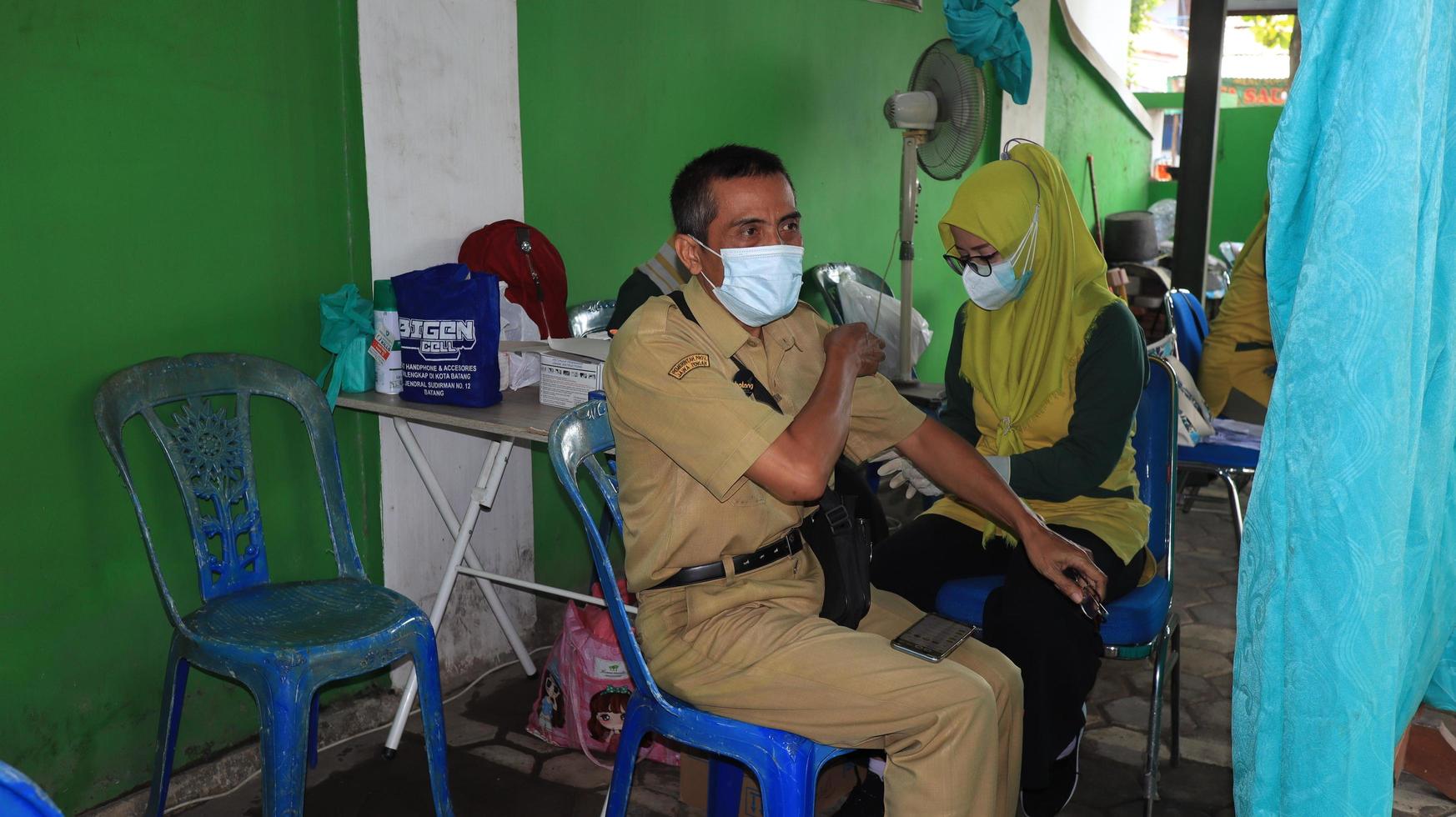 Civil servo recebendo a terceiro cobiçado vacina foto