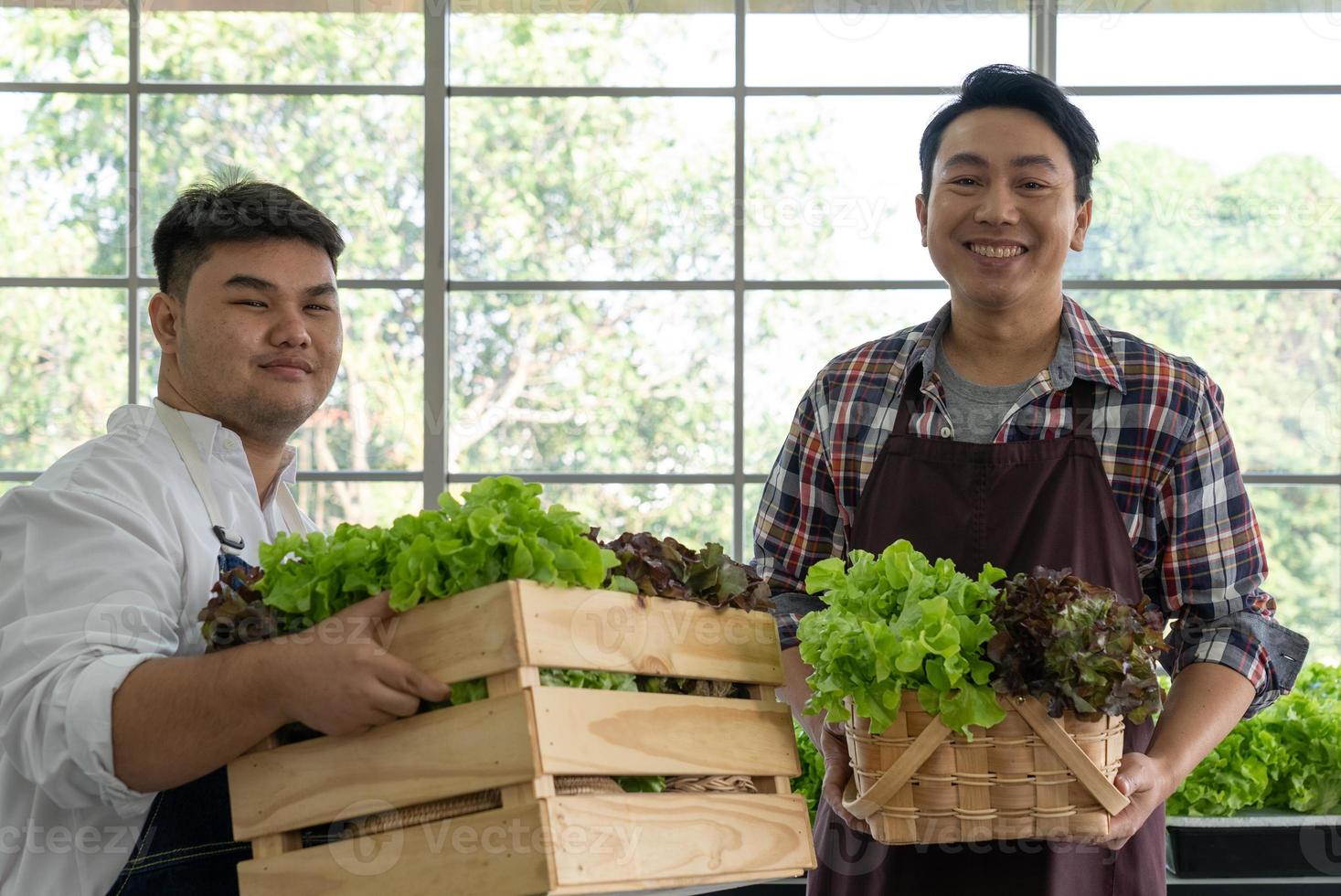 jovem ásia verdureiro vendendo fresco orgânico verde alface em local mercado foto