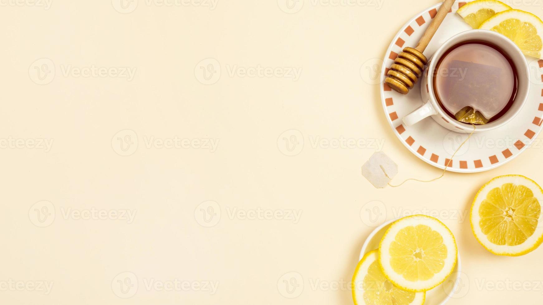 chá preto com fatias de limão fresco em fundo bege foto