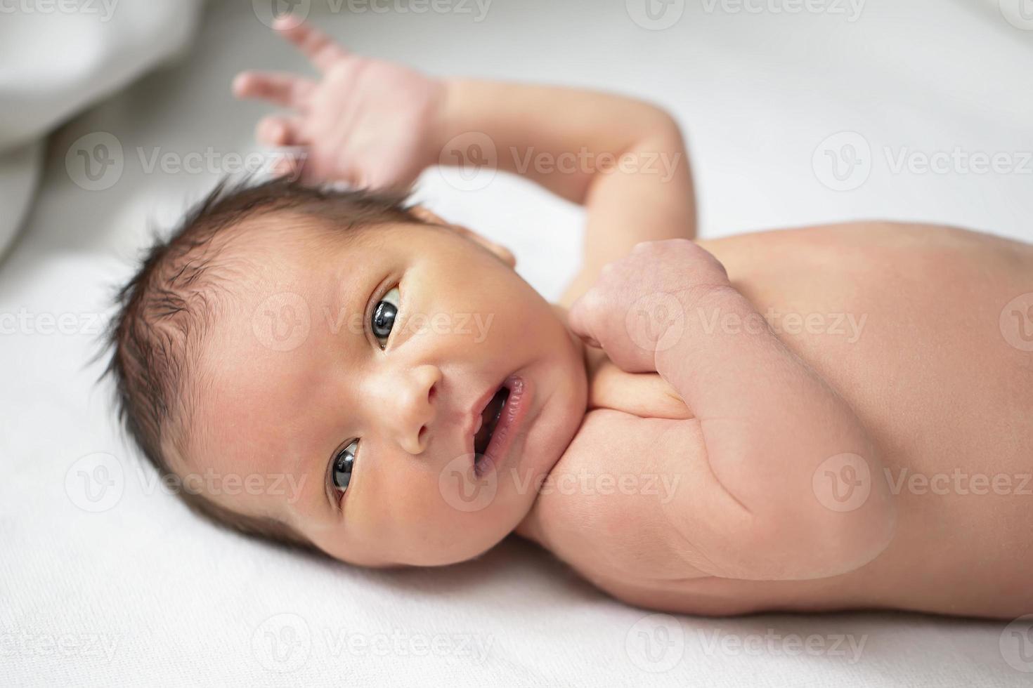 lindo recém-nascido bebê com aberto olhos. os criança é Sete dias velho. foto