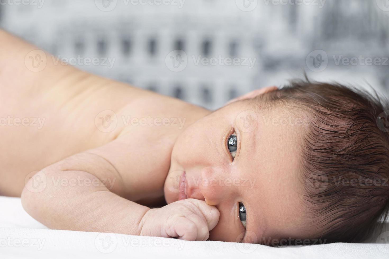 fechar-se recém-nascido bebê retrato. uma bebê com inteligente olhos. foto