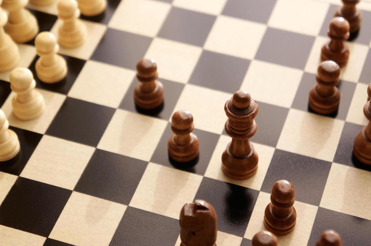 peças de xadrez em um tabuleiro de madeira. vista superior angular do xadrez. foto