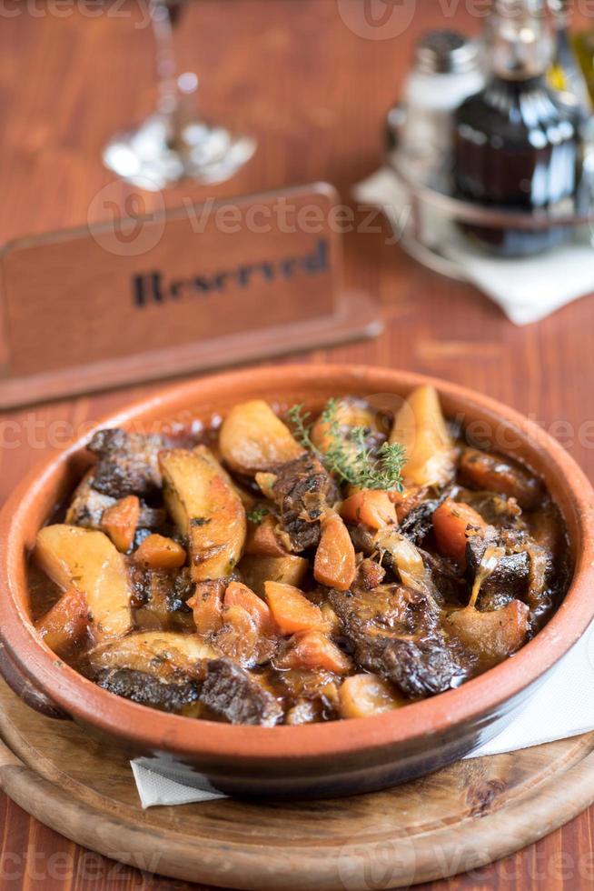 carne e batatas dentro molho servido foto