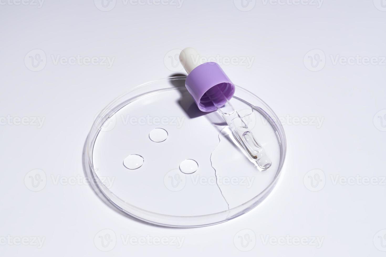 soro de pipeta cosmético em uma placa de petri em fundo branco. conceito de cosmetologia e produtos farmacêuticos. peeling ácido, óleo facial, colágeno. foto
