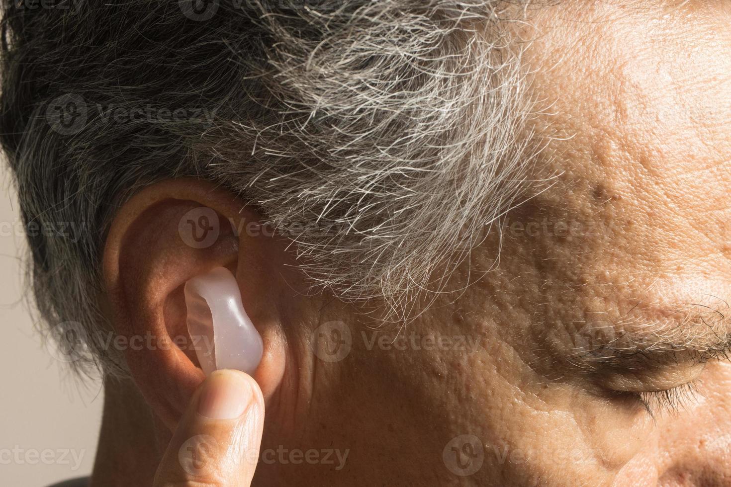 Mais velho homem usando personalizadas fez silicone tampões de ouvido para audição proteção foto