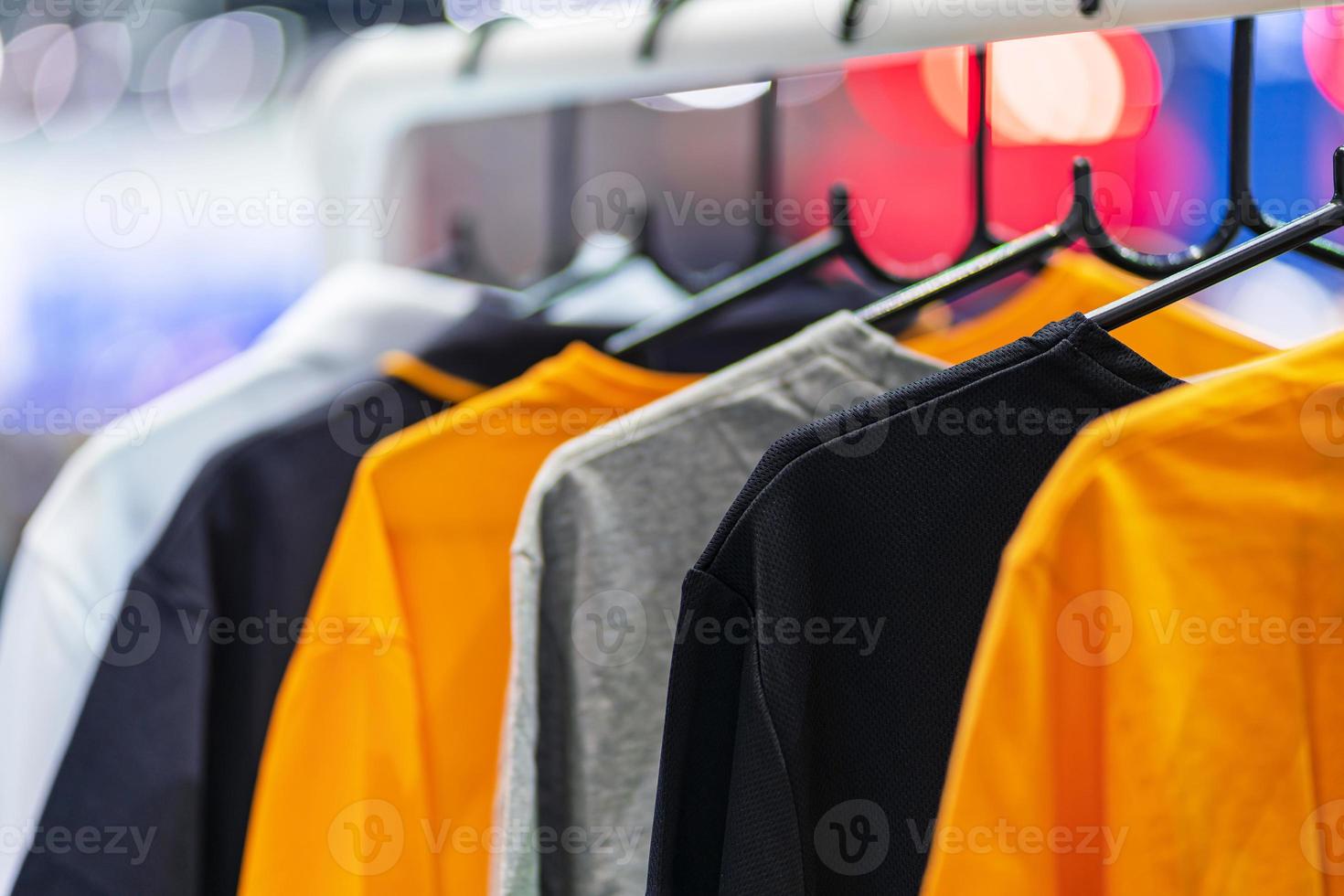 close up de camisetas em cabides, fundo de vestuário foto