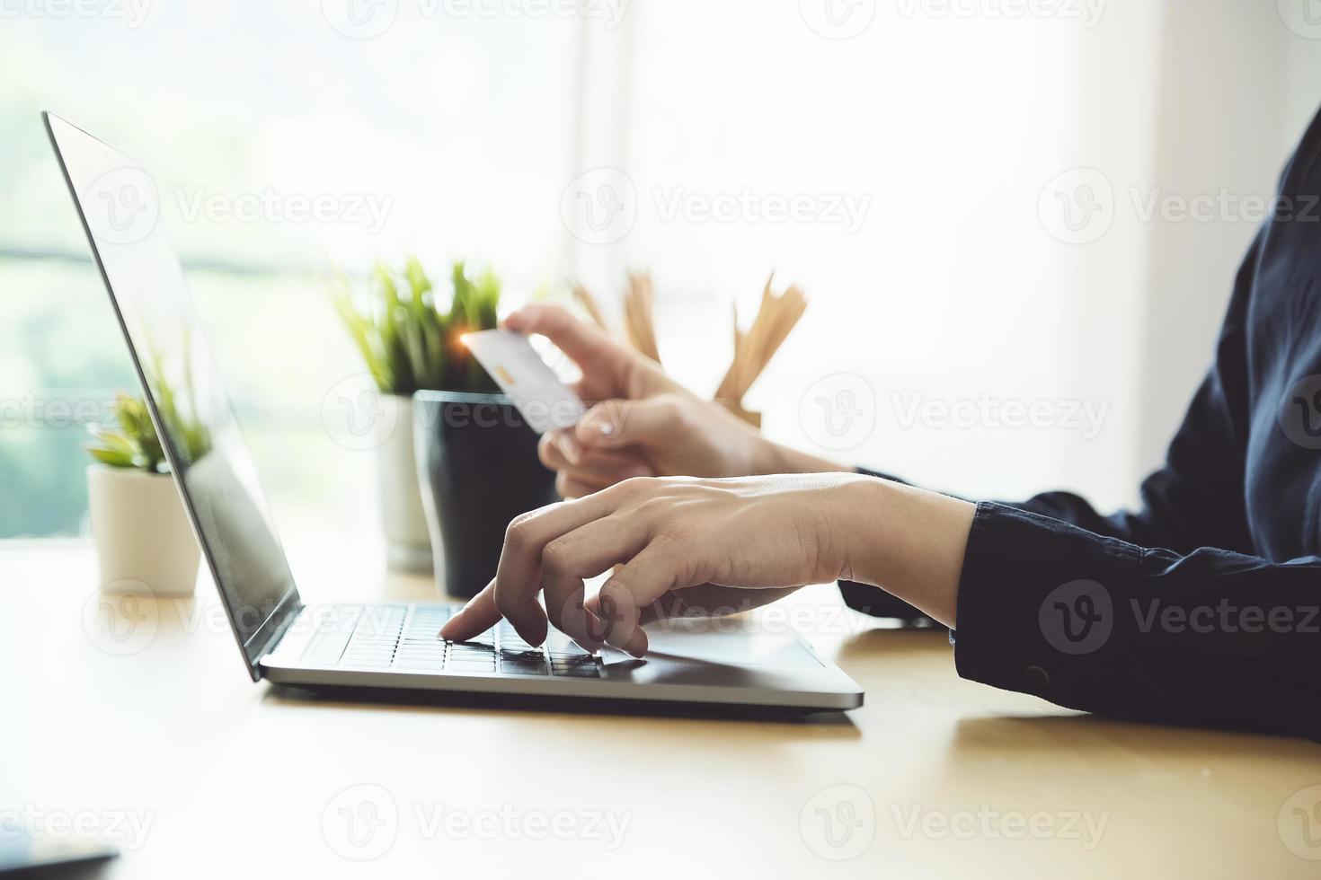 mulher inserindo o número do cartão de crédito em um laptop foto