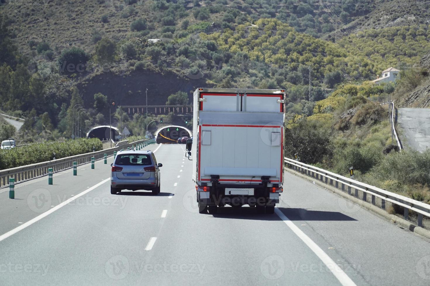 caminhão em uma rodovia - costas visualizar, túnel através montanha foto